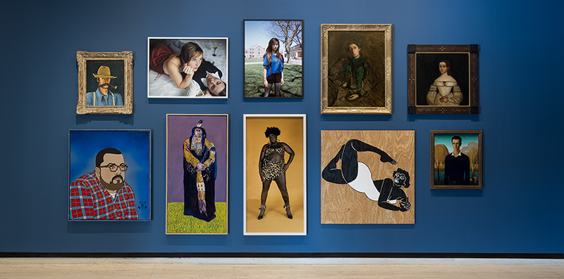 Art gallery wall displaying diverse portraits and photographs in various styles and frames.