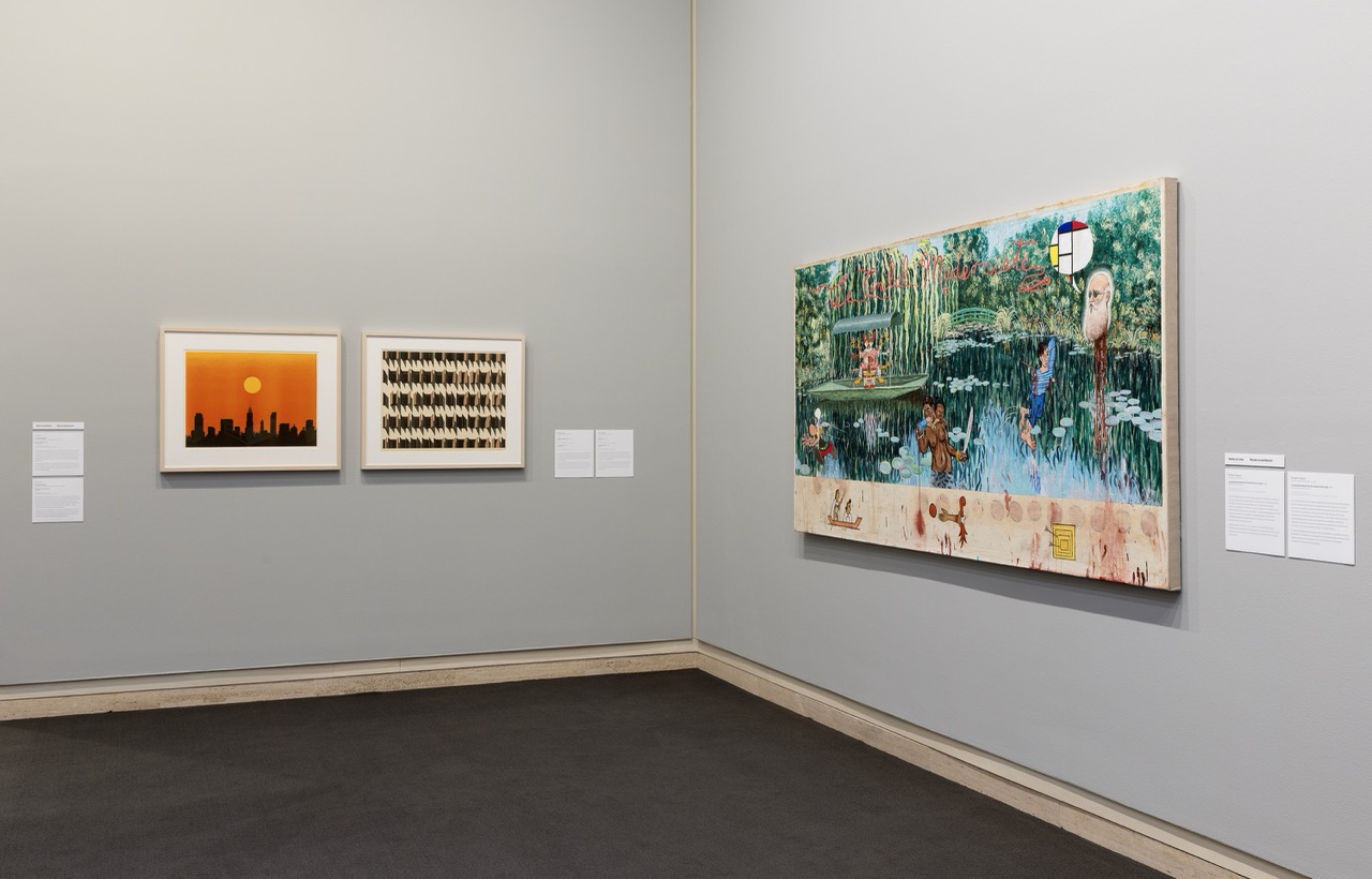 Art gallery wall with framed sunset, grid artwork, and vibrant painting of nature and wildlife.