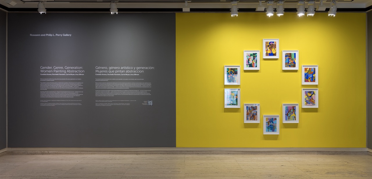 Gallery wall featuring a yellow-painted section with framed abstract artworks arranged in a circle.