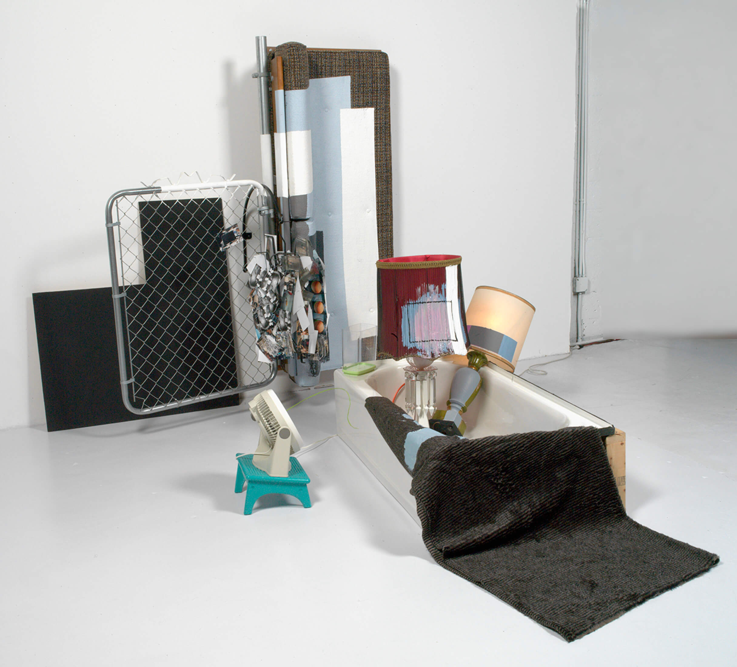 Jessica Stockholder’s monumental work "2000" comprises a bathtub, sofa, accent lamps, and other household objects.