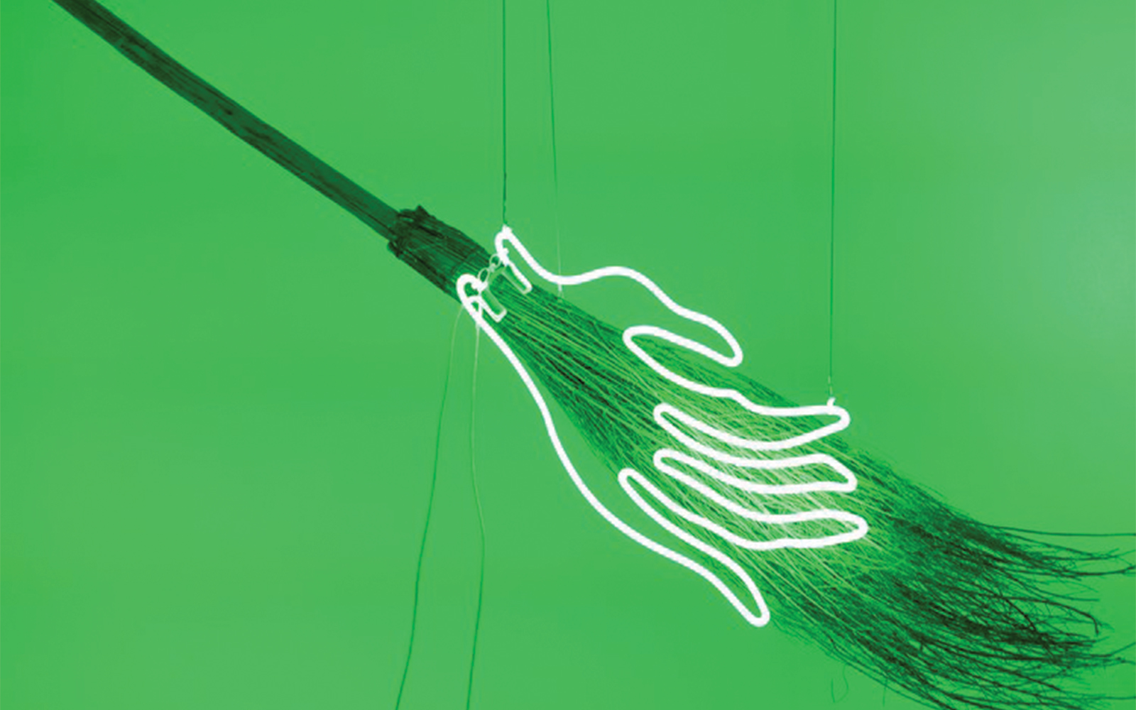 Neon outline of hands gripping a broomstick against a green background.