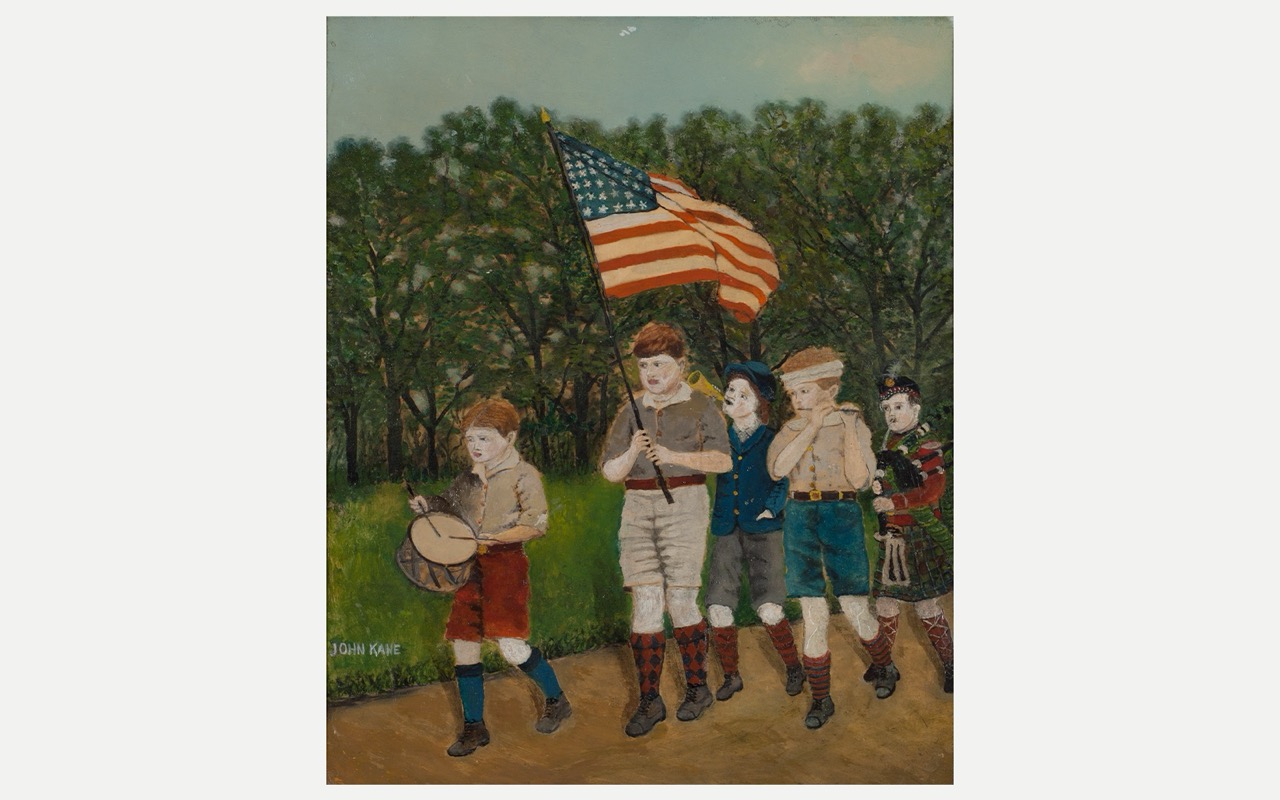 Children marching outdoors with an American flag and a drum, surrounded by trees.