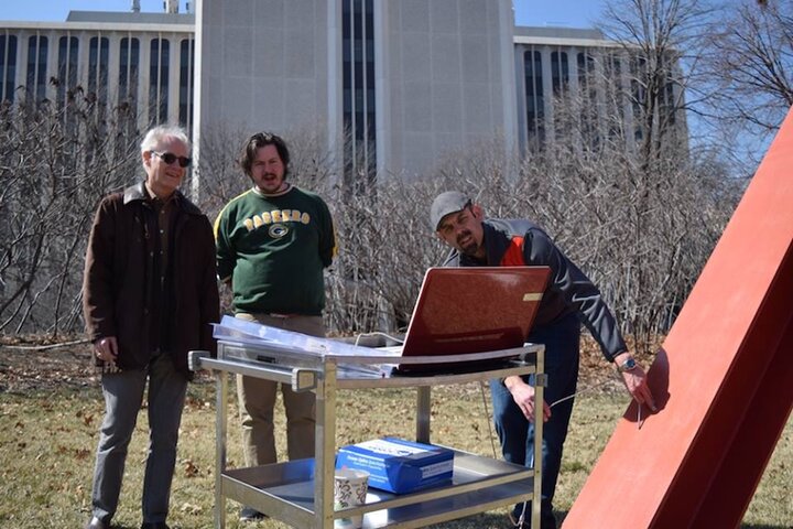 Chemistry professors Mark Griep and Stephen Morin measuring surface reflectance spectra from Mark di Suvero's sculpture "Old Glory."